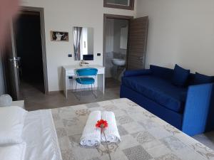 sala de estar con cama y sofá azul en B&B CASA MARTINA, en Giungano