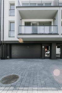 a large white building with a large garage at Apartament JODEŁKA in Szczyrk