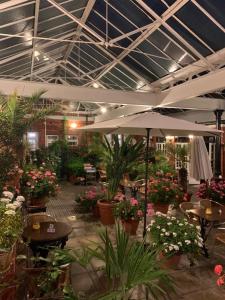 um pátio com mesas e plantas e um guarda-chuva em The Carre Arms Hotel & Restaurant em Sleaford