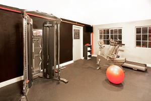 a room with a gym with a chair and a ball at Ramada by Wyndham Pasadena in Pasadena