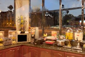 a kitchen with a counter top with food on it at Ramada by Wyndham Pasadena in Pasadena