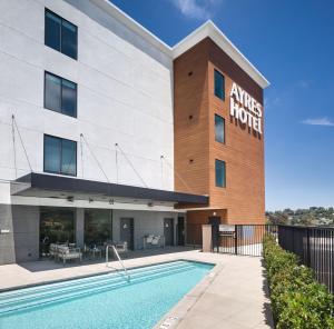 a hotel with a swimming pool in front of a building at Ayres Hotel Vista Carlsbad in Vista