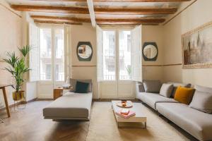uma sala de estar com um sofá e uma mesa em En Ville Boutique Apartments Boqueria Market em Barcelona