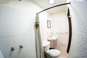 a bathroom with a toilet and a sink at La Fuente Catedral in Puebla