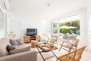 een woonkamer met een bank en een tafel bij Villa Galerna in Son Bou