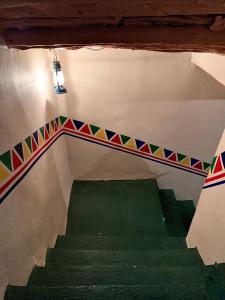 widok na schody z zieloną podłogą w obiekcie بيت القرية التراثية w mieście Tanomah