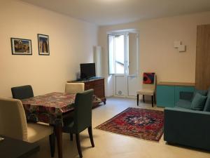 a living room with a table and chairs and a television at Case Rossa e Blu in Villanova dʼAlbenga