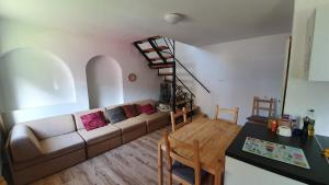 a living room with a couch and a spiral staircase at Littlepanther Balaton in Balatonföldvár