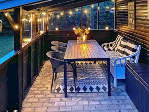 een houten tafel en stoelen op een patio met verlichting bij 6 person holiday home in Hals in Hals