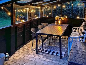 een patio met een houten tafel en stoelen bij 6 person holiday home in Hals in Hals