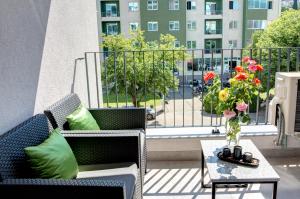 a balcony with two chairs and a table with a vase of flowers at Luxury apartment Concept in Mostar