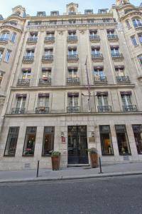 a large stone building with windows and a flag at Villa Margaux Opéra Montmartre in Paris