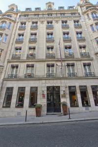 un gran edificio de piedra con ventanas y una bandera en Villa Margaux Opéra Montmartre, en París