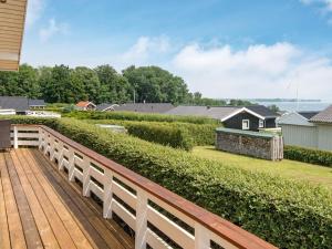 een houten terras met uitzicht op een tuin bij 8 person holiday home in Sj lund in Hejls