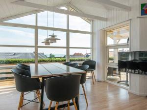 een eetkamer met een tafel en stoelen en een groot raam bij 8 person holiday home in Sj lund in Hejls