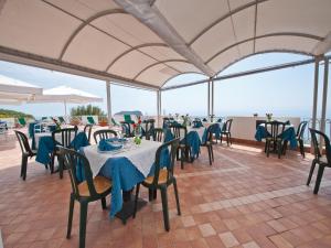 a restaurant with tables and chairs with blue table cloth at Hotel Calabattaglia in Ventotene