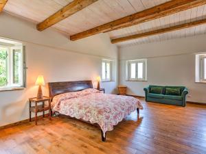 1 dormitorio con 1 cama y 1 sofá verde en Belvilla by OYO Villa Giulia, en Casa Albonetti