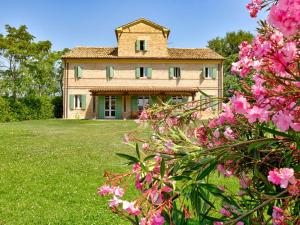 una casa grande con flores rosas delante en Belvilla by OYO Villa Giulia, en Casa Albonetti