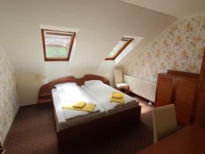 ein Schlafzimmer mit einem Bett mit gelben Handtüchern darauf in der Unterkunft Platán Szálláshely in Sándorfalva