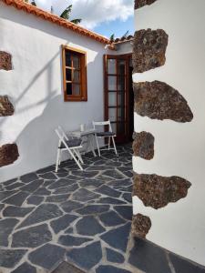 un patio con mesa y sillas junto a un edificio en Casa Los Morros, en Tazacorte