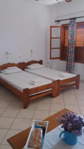 Gialiskari的住宿－ΑΡΜΟΝΙΑ ΣΤΟΥΝΤΙΟ，一张桌子和一张桌子,配有两张床铺。