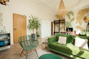a living room with a green couch and a chair at La Paulowna Boutique Hotel in The Hague