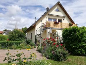 PoseritzにあるFewo Rügen Böttgerの庭の花とバルコニー付きの家