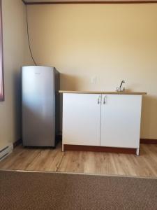 a kitchen with a white refrigerator and a sink at Super Nights Inn in Sault Ste. Marie