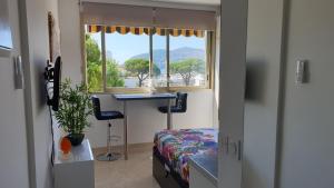 a bedroom with a bed and a desk and a window at Garden and beach sea view apartment Cannes in Mandelieu-la-Napoule