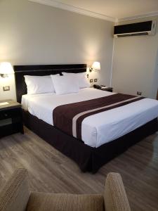 Hotel Diego de Almagro La Serena tesisinde bir odada yatak veya yataklar