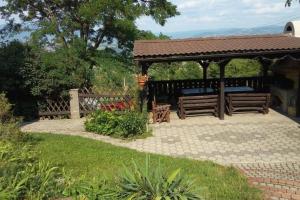a gazebo with two benches in a garden at Bývanie s výhľadom v lokalite Detva in Detva