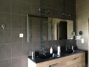 a bathroom with two sinks and a mirror at Chalet des Marmottes in Virton