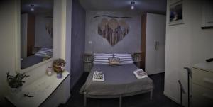 mały pokój z łóżkiem i lustrem w obiekcie Maison Beauregard w Aoście