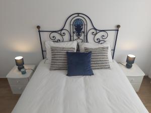 a white bed with two night stands and two lamps at Sun and Beach II AC Wifi 90mts from the Beach in Portimão