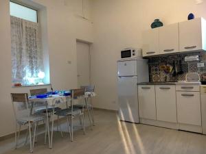 a kitchen with a table with chairs and a refrigerator at Via Aurispa 60 in Palermo