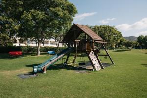 ein Spielplatz mit Rutsche in einem Park in der Unterkunft Apartamento luminoso cerca del mar y la montaña in Puzol