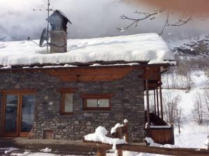 a stone cabin with a snow covered roof at La Maison du Guide in Rhemes-Saint-Georges
