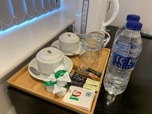 a wooden tray with cups and a bottle of water at Greenwich Stay in London