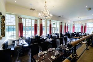 a dining room with tables and chairs and a chandelier at Westone Manor Hotel in Northampton