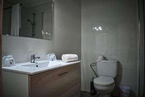 uma casa de banho com um lavatório, um WC e um espelho. em Nice apartment in the center of Can Picafort em Can Picafort