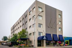 a large white building with blue awnings on it at Bridgewater Hotel, Trademark Collection by Wyndham in Fairbanks