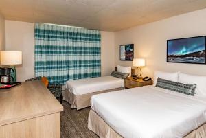 a hotel room with two beds and a tv at Bridgewater Hotel, Trademark Collection by Wyndham in Fairbanks