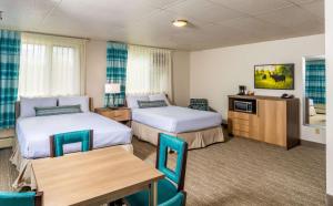 a hotel room with two beds and a table at Bridgewater Hotel, Trademark Collection by Wyndham in Fairbanks