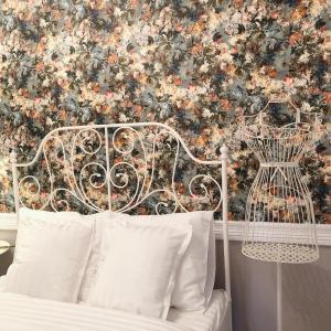 a bedroom with a white bed with a floral wallpaper at VIP 67 in Eupen