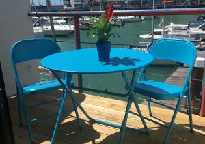 a blue table with two chairs and a potted plant at Brighton Marina Floating home in Brighton & Hove