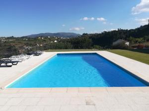 una piscina con agua azul en un patio trasero en Quinta da Portelada en Peso da Régua