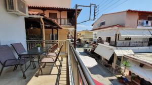 a balcony with a table and chairs on a building at Vasiliki House in Sarti