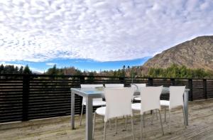 a table and chairs on a deck with a view at Treehouse Spa Escape - Private Spa Pool in Queenstown