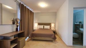 a bedroom with a bed and a bathroom with a sink at Vasiliki House in Sarti