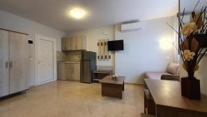 a living room with a couch and a kitchen at Vasiliki House in Sarti